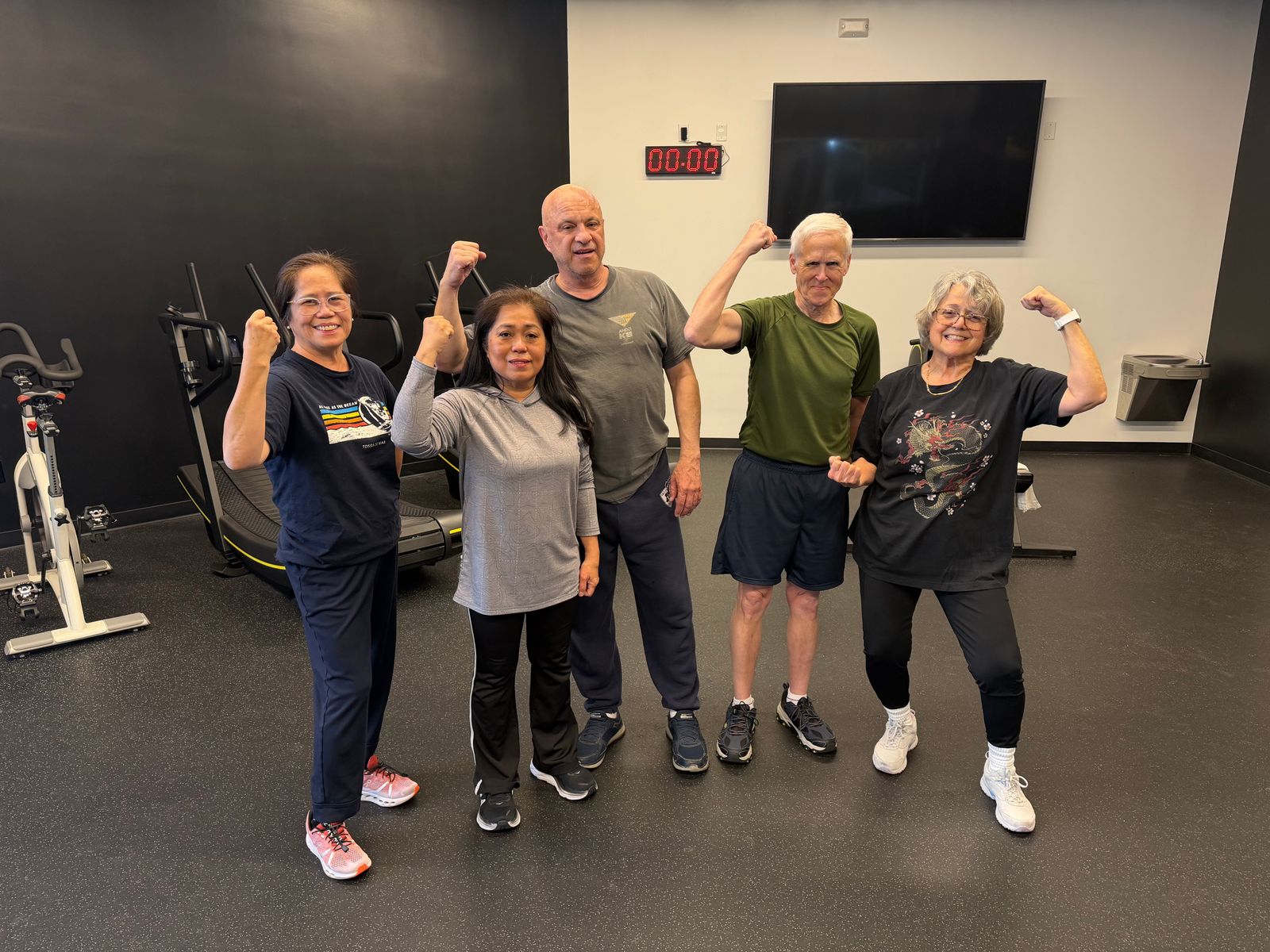 Five members flex together in the group training studio