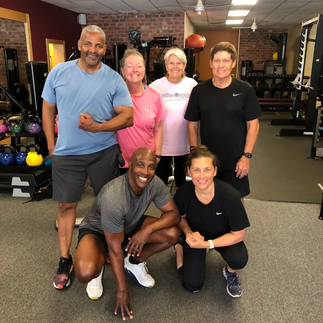 Six members pose together in the studio, one in a “Live Life on Your Own Terms” tee